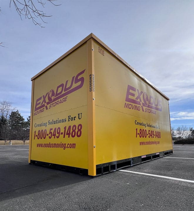 A large yellow storage container in a parking lot with branding for a moving and storage company.